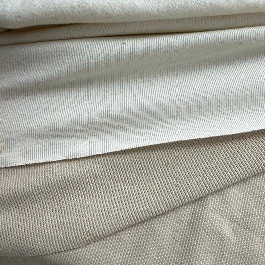 Close-up of rib knit and 2x1 rib knit fabric in neutral colors, showing stretch texture.