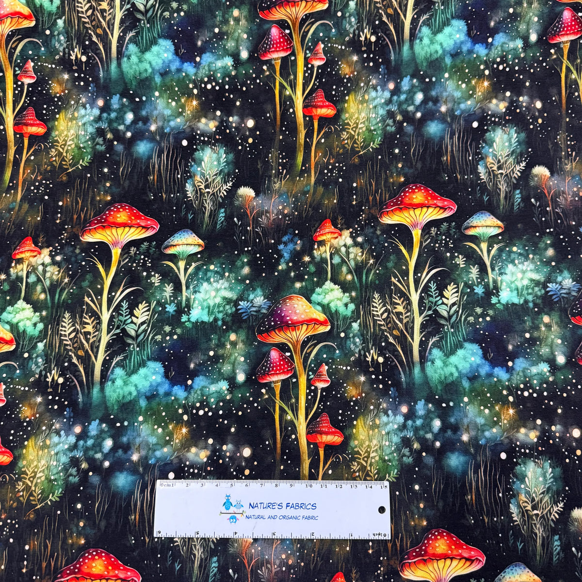 Nature's Fabrics magical forest mushroom print fabric with glowing colorful fungi.