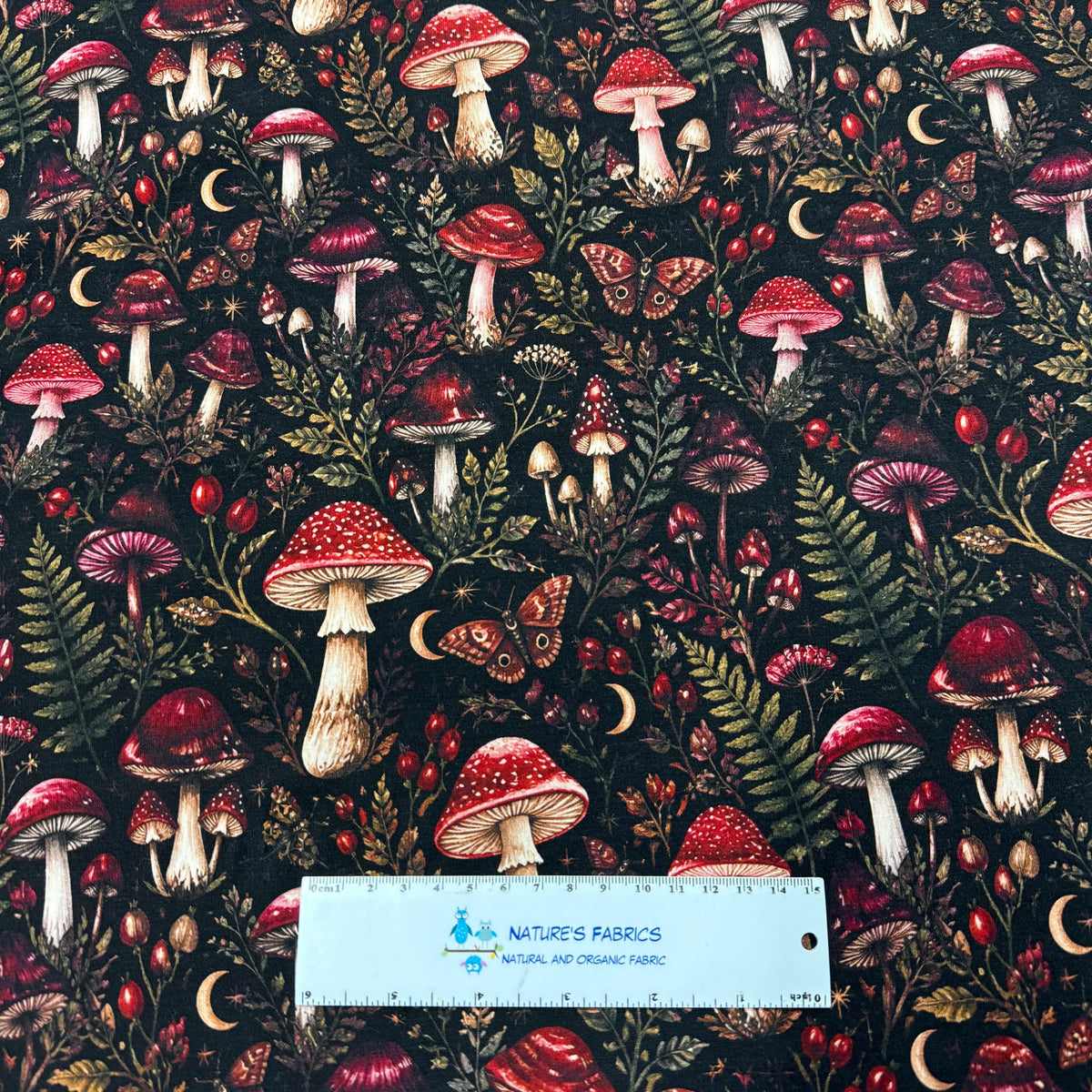 Nature's Fabrics organic cotton fabric with red mushrooms and forest foliage pattern