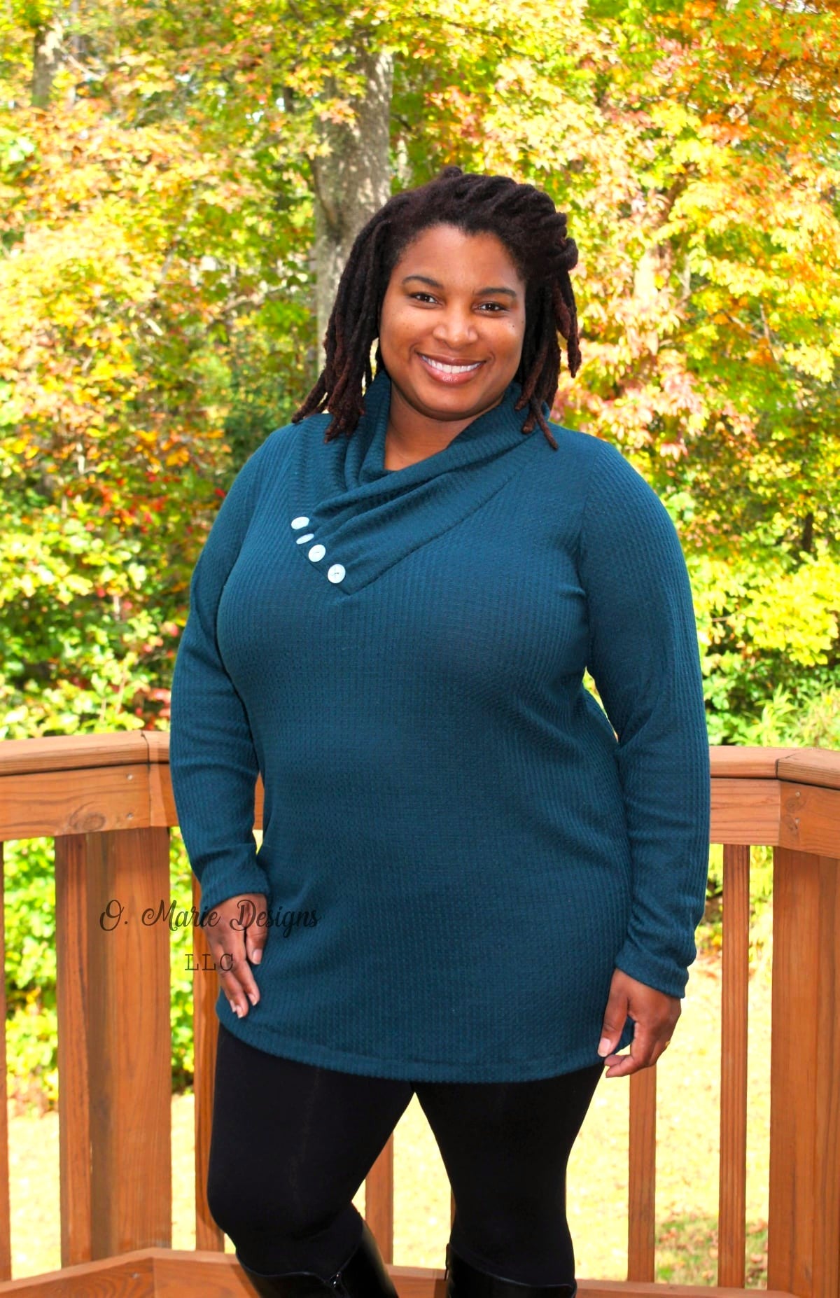 Woman wearing a teal sweater with buttons in an outdoor setting