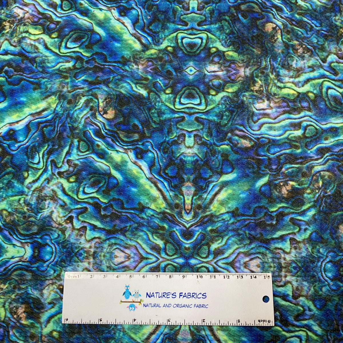 Nature's Fabrics abstract blue green patterned natural fabric with ruler for scale, showcasing organic textile design
