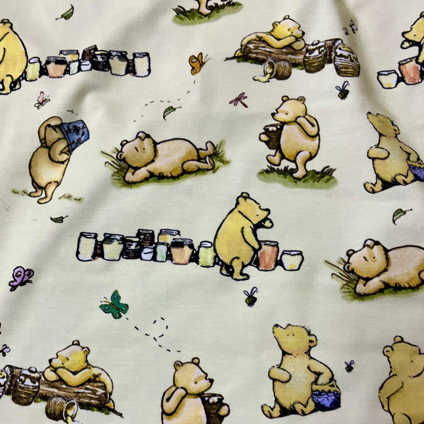 Winnie the Pooh and Honey Pots on Cream Bamboo/Spandex Jersey Fabric - Nature's Fabrics