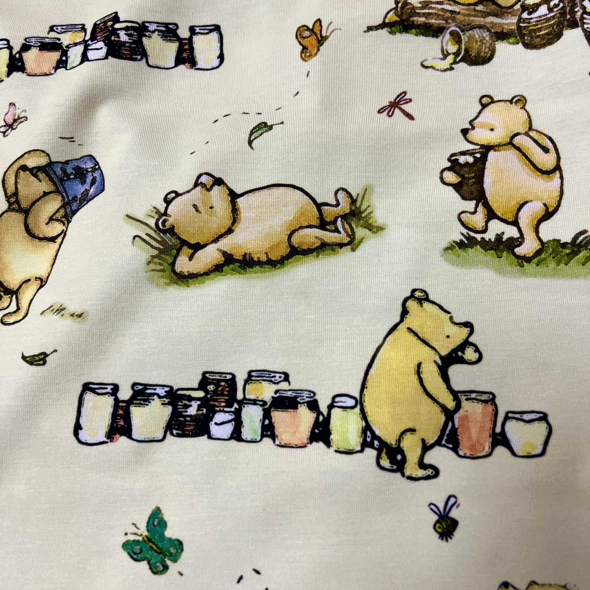 Winnie the Pooh and Honey Pots on Cream Bamboo/Spandex Jersey Fabric - Nature's Fabrics