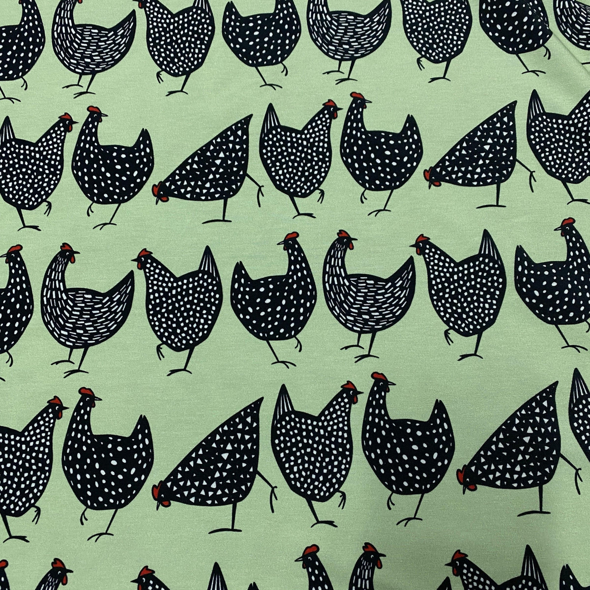 Nature's Fabrics light green fabric with a pattern of black and white dotted chickens